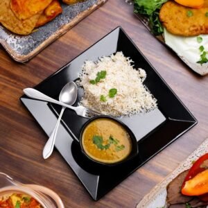 Authentic Pakistani meal with rice, curry, and assorted sides served on a wooden table.