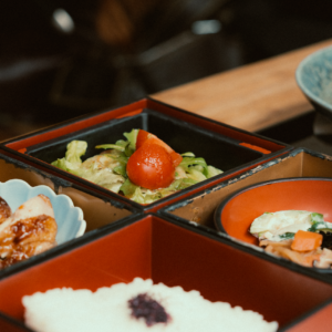 A beautifully presented Japanese bento box featuring diverse dishes with a variety of ingredients.