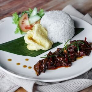 Delicious Indonesian platter with rice, omelette, and spicy beef rendang.